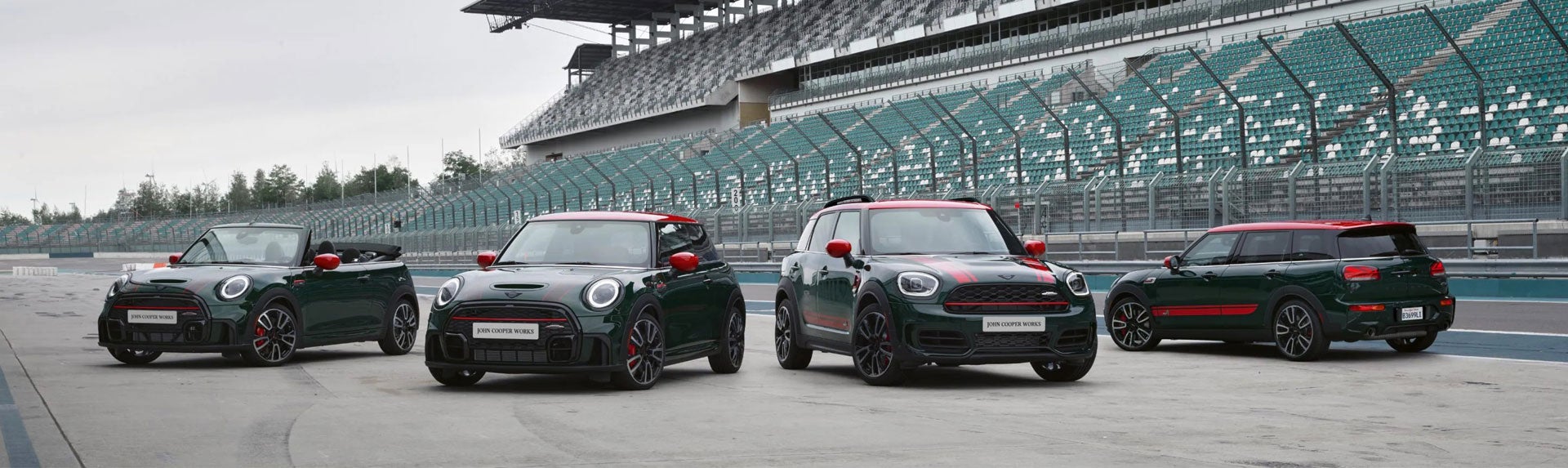 Family of four MINI John Cooper Works models parked on a race track. | MINI of Madison in Madison WI